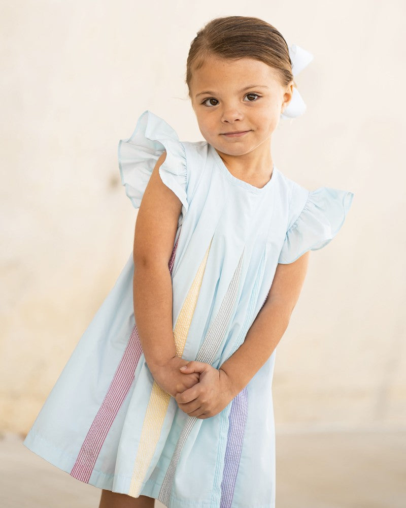 white dress with rainbow pleats This white layered dress is a classic, adorned with pastel rainbow stitching along the layers and adjustable shoulder ties